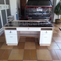 โต๊ะทำงาน 160 cm ท็อปกระจกสีชาดำ ตัวโต๊ะสีโซลิด หน้าบานสีขาว วางอยู่หน้าบ้าน